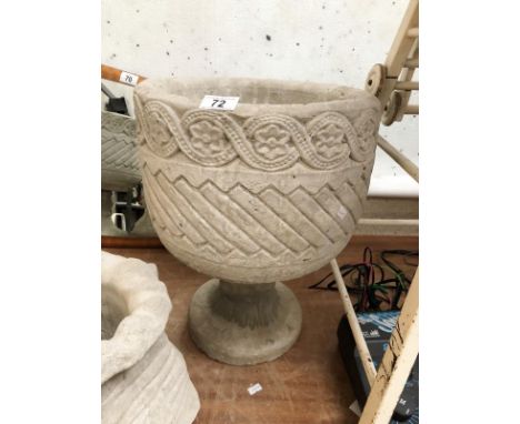 A mayan circular planter with aztec design.