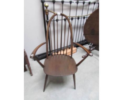 A dark Ercol elbow chair.