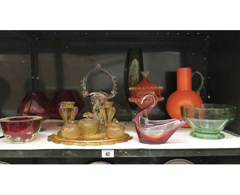 A shelf of art glass including amber glass dressing table set.