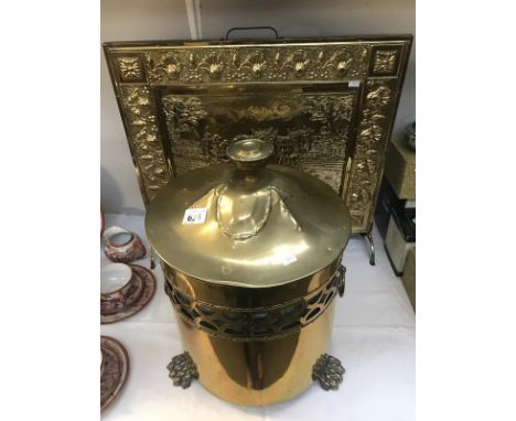 A brass firescreen and a coal bucket.