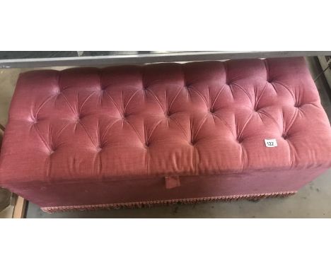 A pink Draylon covered ottoman with deep button top.