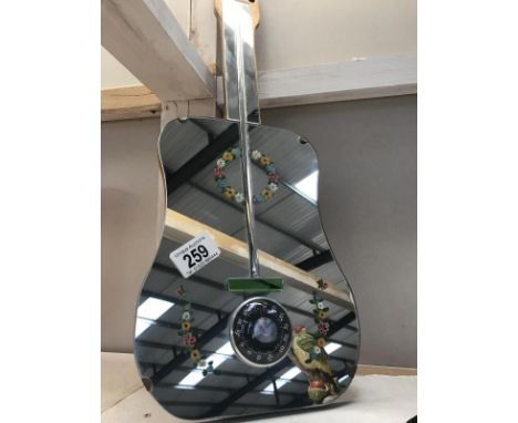 A retro barometer in the shape of a guitar. 