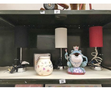 A shelf of table lamps etc. including a frog money box.