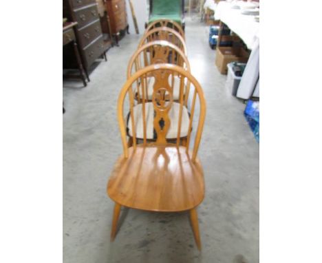 A set of 4 light Ercol 'Fleur-de-lys' dining chairs.