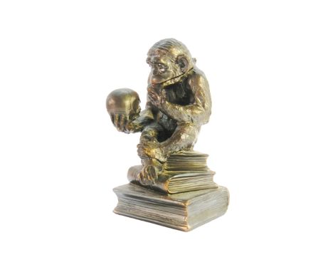 A metal table lighter in the form of a monkey modelled on 'The Thinker'.