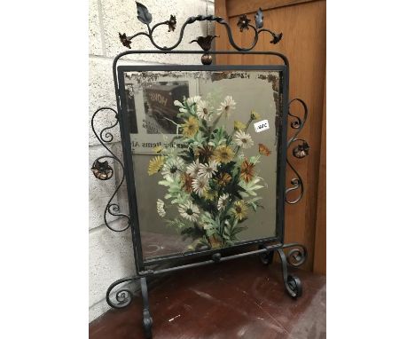 A wrought iron firescreen with hand painted mirror insert.