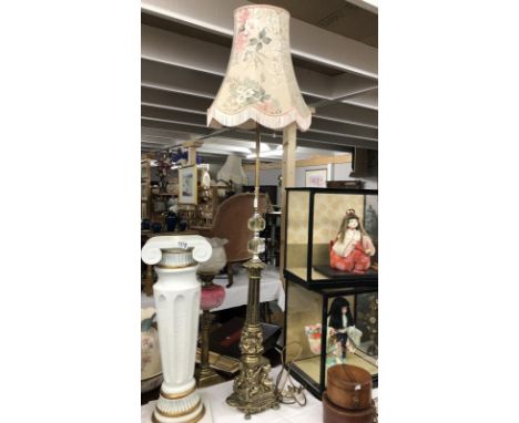 A gilded standard lamp with cherubs on base complete with shade,.