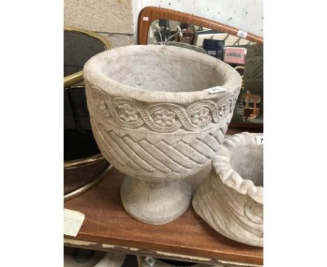 A mayan circular planter with aztec design.