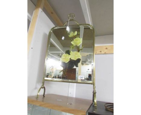 A brass framed firescreen with hand painted floral bevel edged mirror.