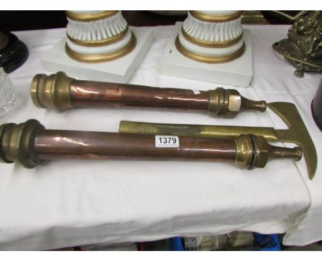 2 brass and copper fireman's hoses together with a fireman's axe.