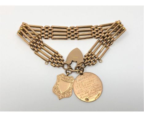 A 9ct gold gate bracelet with two 9ct gold fobs attached, 23g.