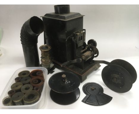 An early 20th Century tin plate projector with various slides and film reels.