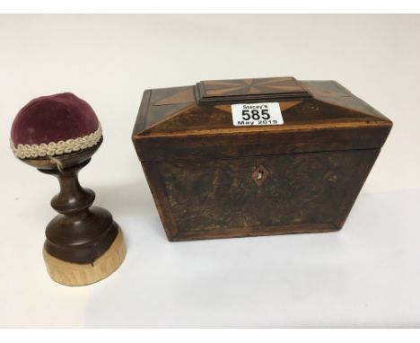 A 19th century Regency parquetry burr walnut and satinwood tea caddy and a turned hardwood pin cushion (2)