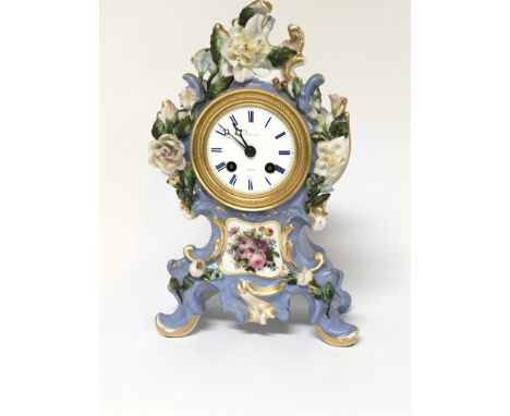 A Quality French Porcelain mantel clock the cased with raised flowers and foliage. With a half hour striking Silk suspension 