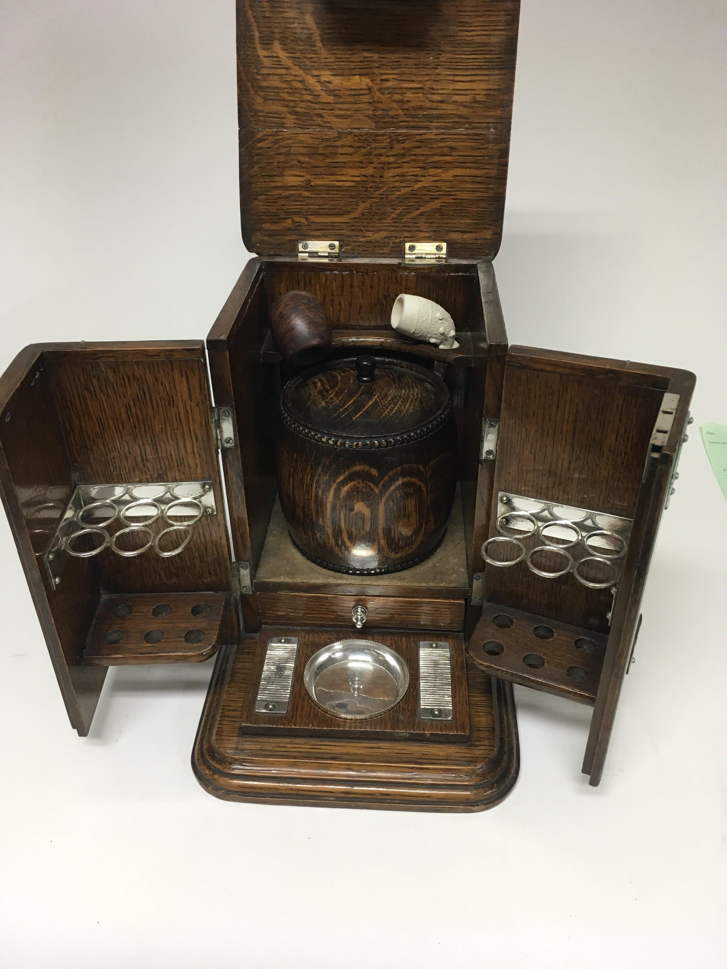 A oak smokers box containing pipes and tobacco box