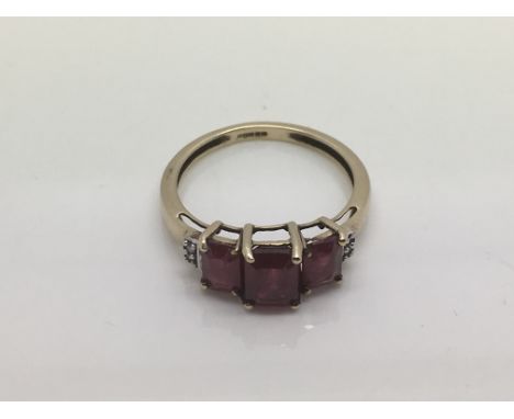 A 9ct gold, diamond and ruby three stone ring, approx 2.3g and approx size N.