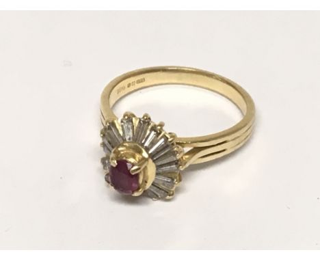 An 18carat gold ring set with a central ruby flanked by baguette diamonds. ring size O.