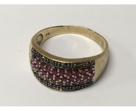 A Gents 9carat gold ring set with rubies and black diamonds. Ring size X.