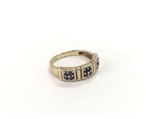 A 9ct gold ring set with three groups of 4 small sapphires. Weight approx 3.07g. Ring size approx N 1/2.