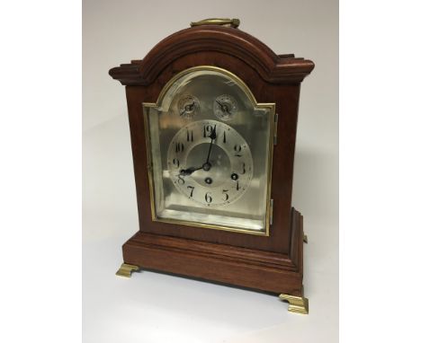 A Mahogany mantel clock with a silvered dial brass mounts strike silent seen working. Height 38cm.
