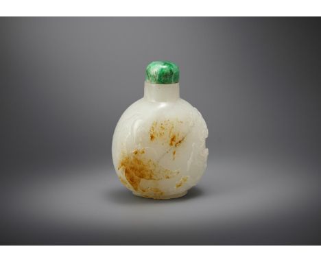 A Chinese white and russet jade snuff bottle, 19th century, of oval shape and the exterior carved butterfly in flight next to