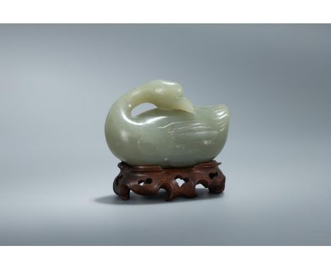 A Chinese celadon jade model of a goose, Qing Dynasty, the bird recumbent with its legs tucked under and its head resting on 