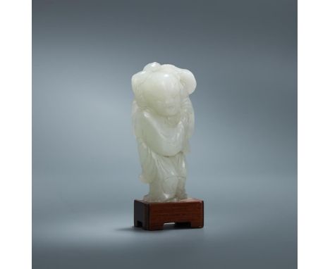 A Chinese white jade figure of a boy, Qing Dynasty, carved standing with a jovial expression, both hands carrying a stalk bea