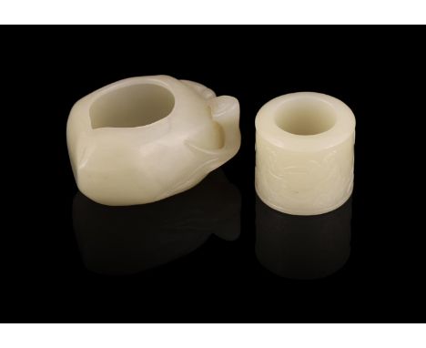 A Chinese celadon jade washer, Qing Dynasty, 6.2cm long; and a Chinese celadon jade archer's ring, 19th/20th century, carved 
