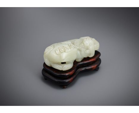 A Chinese pale celadon or white jade lion, Ming dynasty, of even tone, carved as a Buddhist lion with bushy brows and ruyi-sh