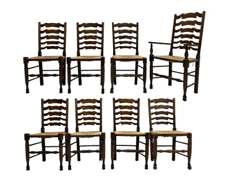 Matched set of eight (7+1) oak ladder back dining chairs, waved ladder back over rush seats, on turned supports joined by tur