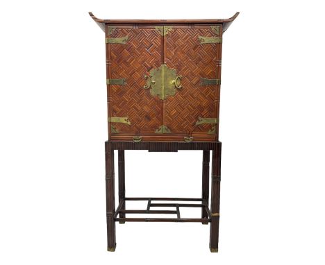 Chinese design bamboo and wood altar cabinet on stand, parquetry lattice-work bamboo, two doors with engraved metal fixtures 