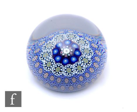A contemporary Twists Glass paperweight, designed by Mike Hunter, of domed form internally decorated with a central white dai