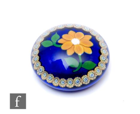 A late 20th Century William Manson glass paperweight of domed form, internally decorated with a large lampwork stylised yello