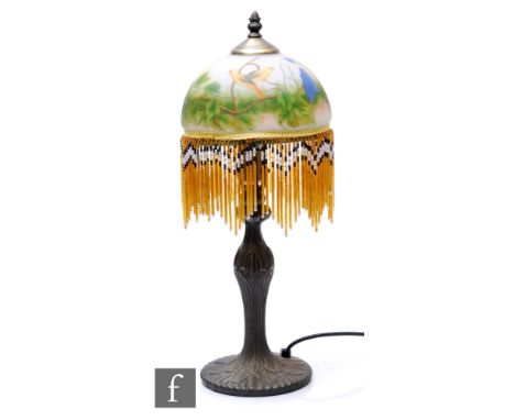 A reproduction Art Deco style table lamp, the frosted glass shade of domed form and decorated to the interior with hand paint