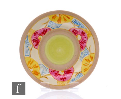A Clarice Cliff circular side plate hand painted in the Hollyrose pattern with a border of stylised flowers and foliage, widt