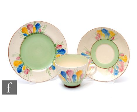 A Clarice Cliff Spring Crocus tea cup, saucer and plate hand painted with stylised flowers and foliage with pale green and br