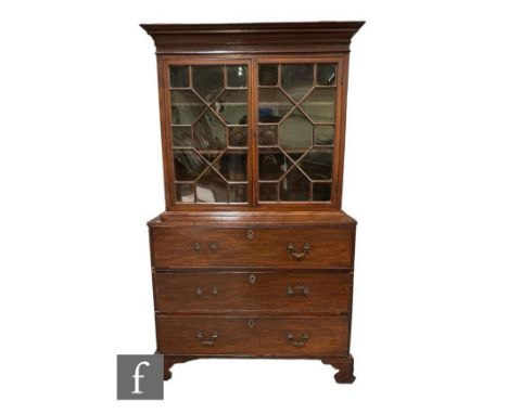 A George III mahogany secretaire bookcase enclosed by a pair of astragal glazed doors below a fluted cornice over a base fitt