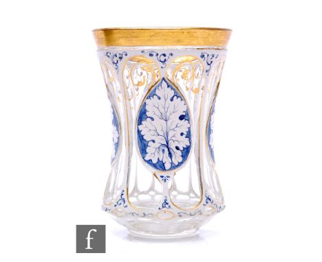 A 19th Century Bohemian beaker of footed and waisted form, cased in opal over clear crystal and cut with repeat panels with f