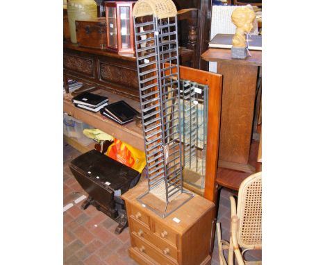 A small pine chest of two short and two long drawers, a bevelled wall mirror in pine frame and a CD tower rack 