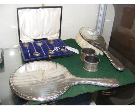 A silver backed dressing table mirror and brush, together with napkin rings and teaspoons