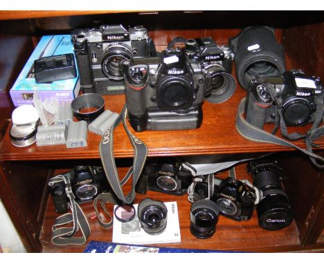 Vintage photographic equipment, including Nikon D200 and Canon T90 - on two shelves 