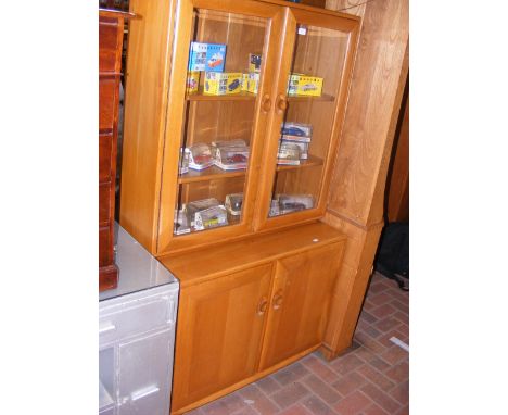 An Ercol Golden Dawn cabinet with cupboards below