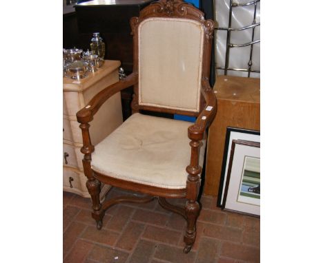 An oak framed armchair with upholstered back panel and seat