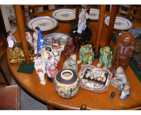 An assortment of oriental collectables, including carved wooden figures and ceramic ornaments 