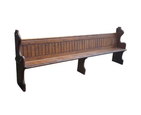 A large 19th century stained pine church pew, both ends with brass handles, numbered to '39' and '17' to both ends, width 282