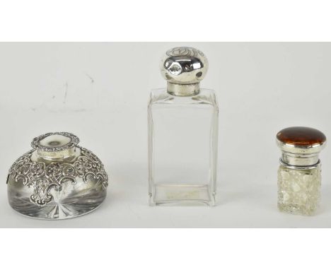 Three items of silver topped glass comprising a blown glass inkwell of dome shape, with pierced silver floral and scroll top 