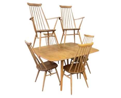 ERCOL; a light elm drop-leaf dining table, with six spindle back chairs comprising four dining chairs and two carvers, table 