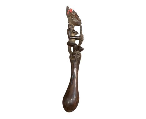 A carved wooden Igbo pestle, the top surmounted with carved figural decoration of a lady smoking a pipe, length 48cm.