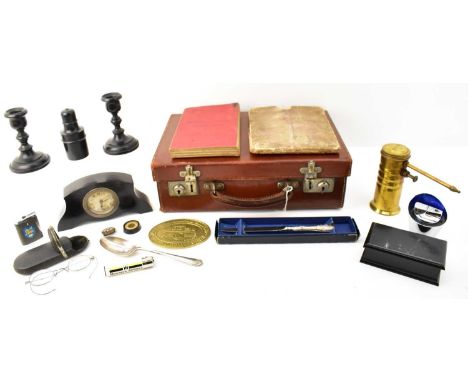 A small brown leather child's travel case containing various collectables, including a small ebonised mantel clock, length 17