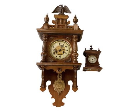 An early 20th century walnut cased wall clock, the top surmounted with decoration of an eagle, height approx 90cm, and an ear